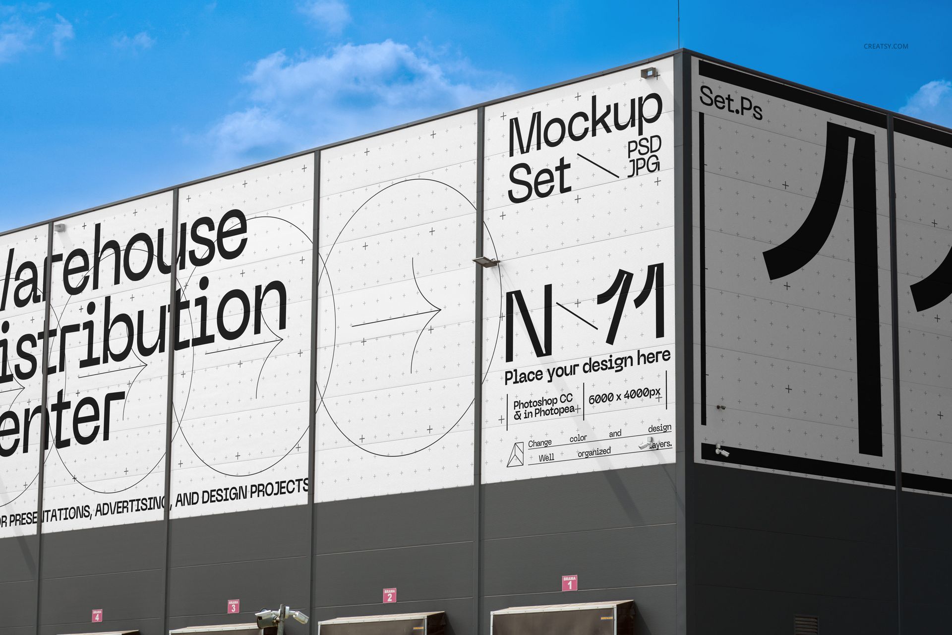 Front view of a warehouse distribution center building with large white advertising mockup panels and bold black text.