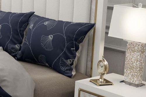 Close-up of a bedding mockup set showing navy pillows with white abstract designs, beige blanket, and elegant decor.