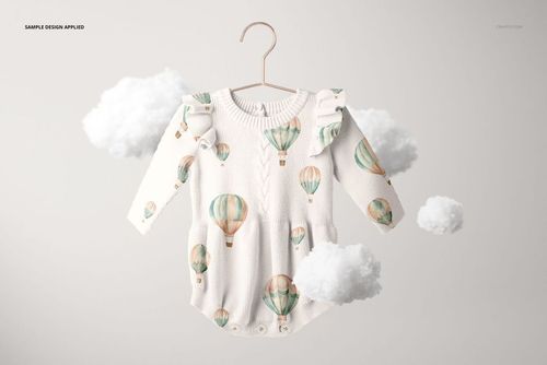 Knitted long-sleeve baby romper mockup suspended from a hanger, featuring soft pastel balloon designs and floating clouds.