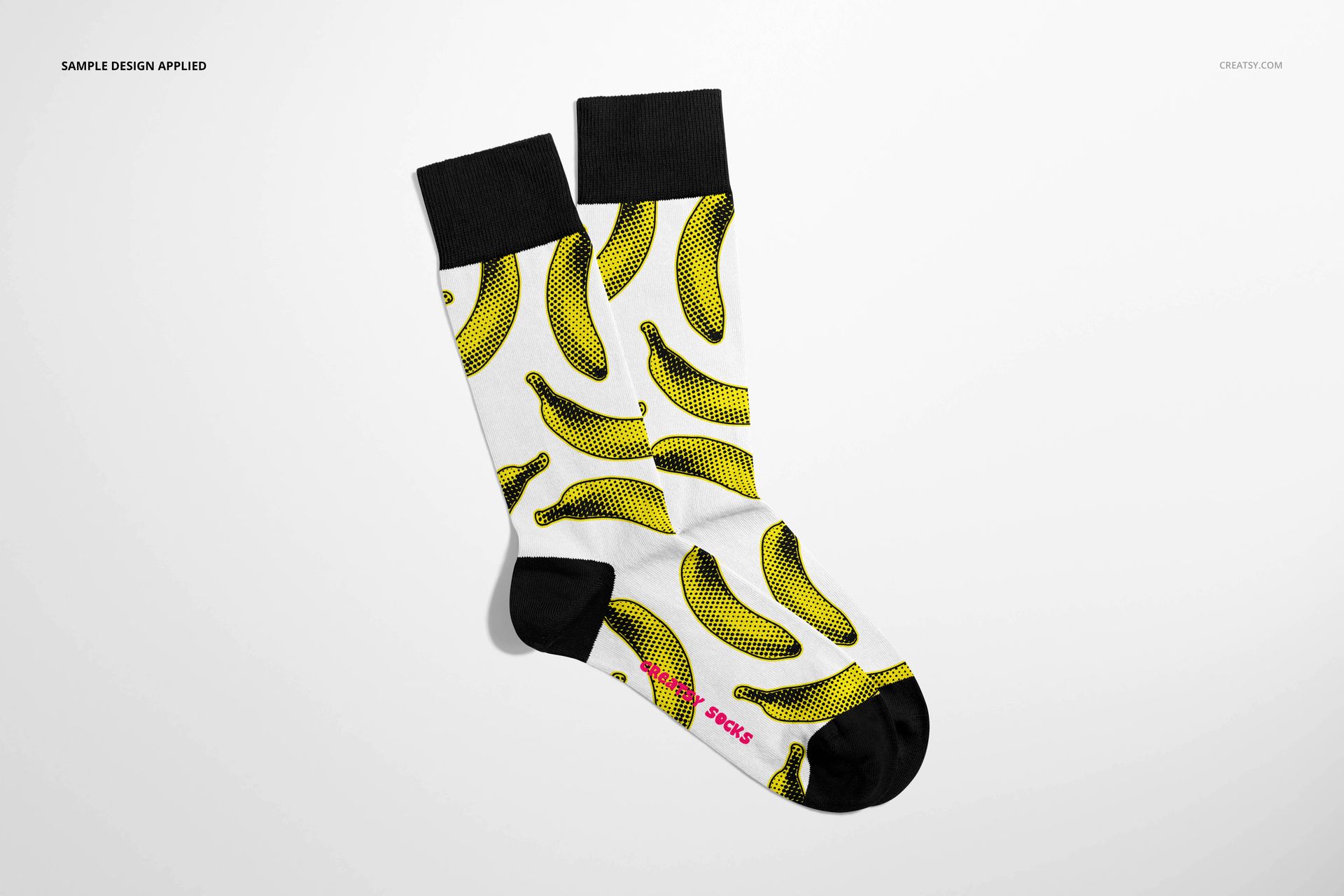 High cuff socks mockup displayed from above, showing black accents and a bold yellow banana print on white fabric.