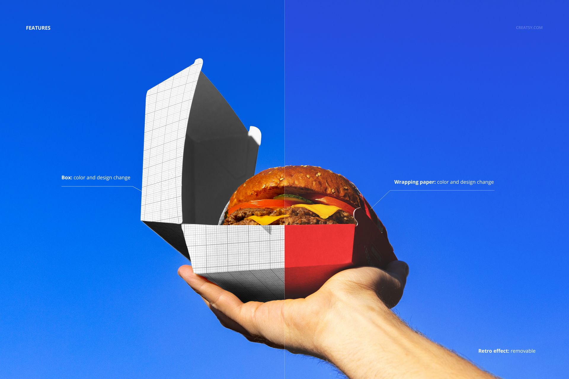 Hand holding an open burger box with a hamburger inside against a clear blue sky, shown in a PSD mockup style.
