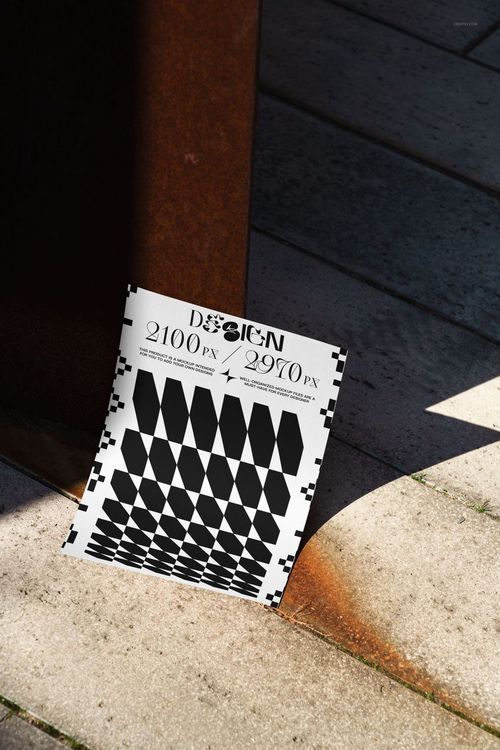 PSD mockup of a modern poster with abstract black and white design, resting on light stone tiles beside rusted metal.