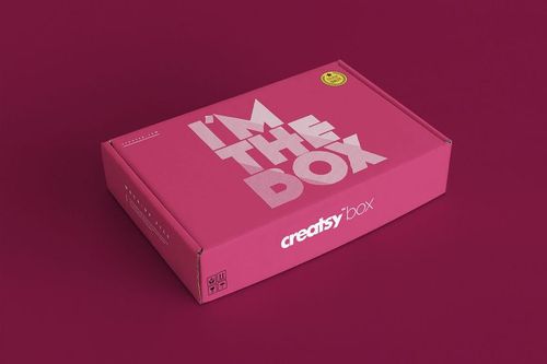 Pink packaging box mockup with large white lettering, displayed at an angle against a burgundy backdrop.