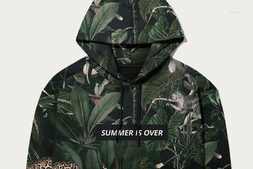 Front view of a Gildan 18500 hoodie mockup featuring a dark green tropical leaf pattern and bold white text on the chest.