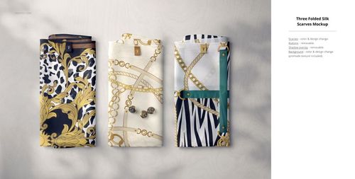 Three folded silk fabric pieces with gold chain and animal print patterns, arranged side by side on a light surface.