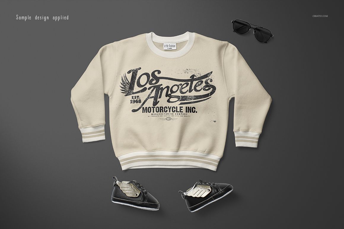 Front view of a baby sweatshirt mockup in beige with a vintage Los Angeles motorcycle graphic, placed on a gray background.