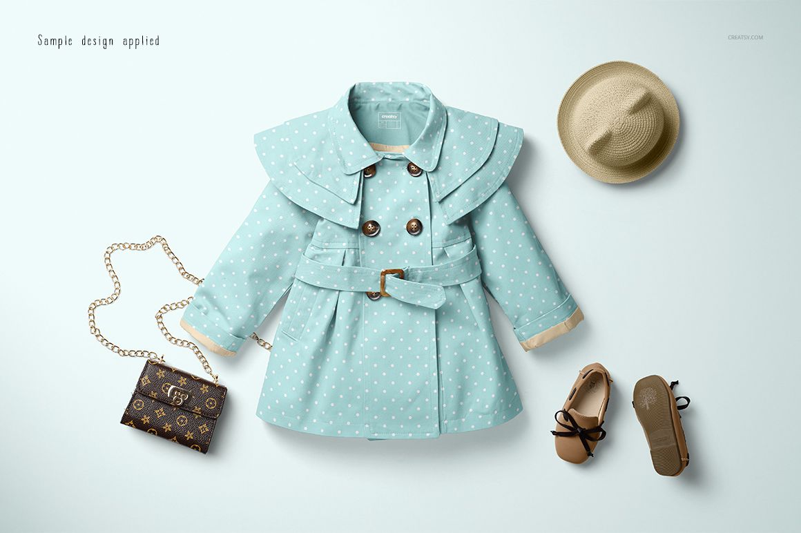 PSD mockup showing a baby coat in light blue with white polka dots, styled alongside a straw hat, purse, and shoes.