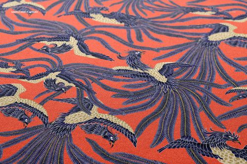 Scuba fabric mockup featuring a close-up view of blue and cream bird pattern on a vibrant orange textile surface.