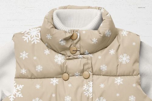 Front view of a boys winter set mockup featuring a beige puffer vest with white snowflake patterns over a white ribbed sweater.