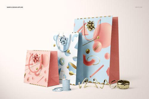 Paper bags mockup featuring pink and blue bags with abstract prints, decorative bows, and ribbon spools on display.