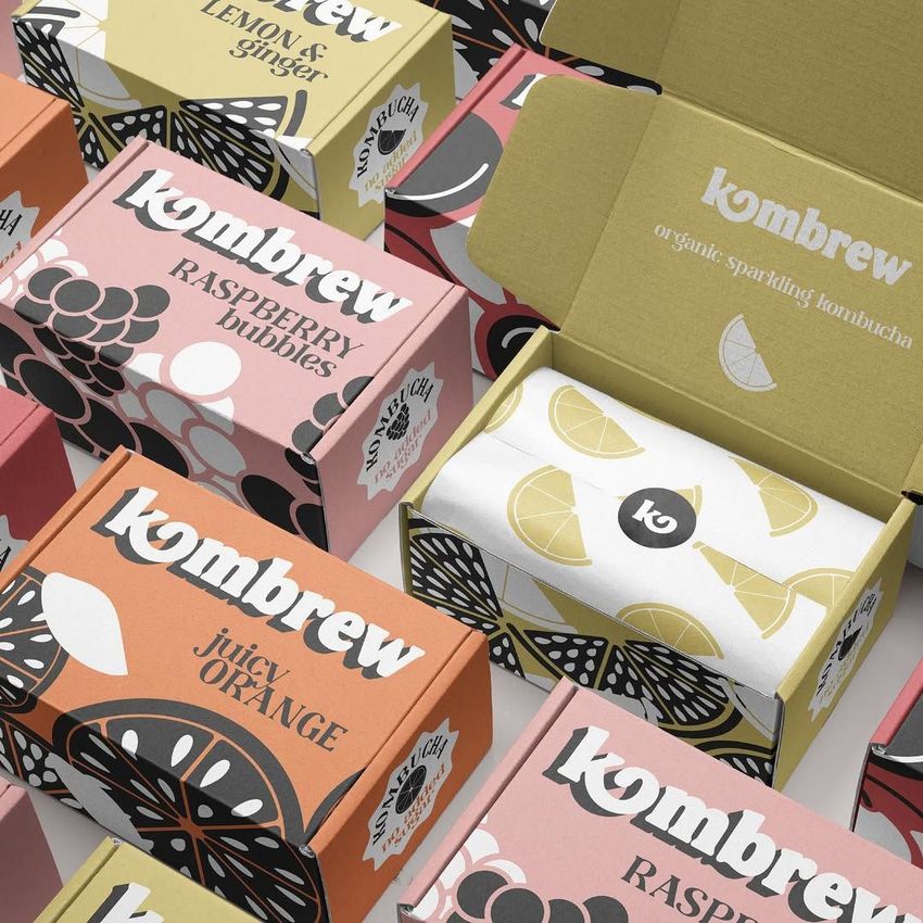 Packaging mockup featuring multiple mailing boxes with colorful fruit illustrations and bold text, viewed from above.