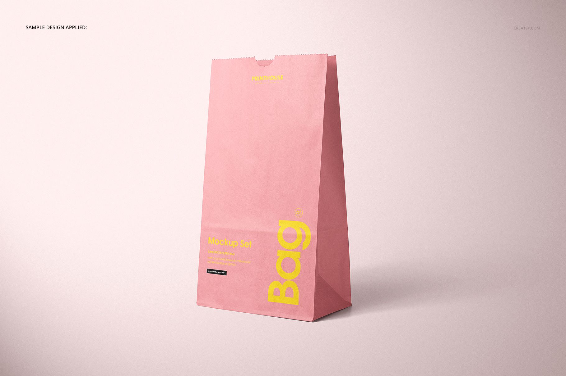 Front view of a pink lunch bag with yellow text, standing upright on a light surface in a PSD mockup scene.