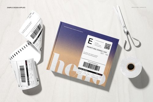 Shipping label mockup set featuring a roll of printed labels, a cardboard box with a label, and scissors on a light surface.