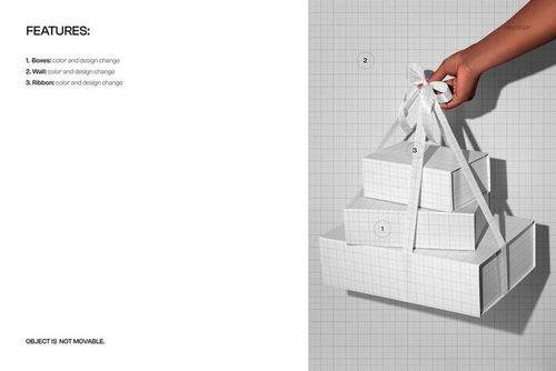 Hand holding a stack of three magnetic boxes with a white ribbon, shown in a PSD mockup on a grid background.