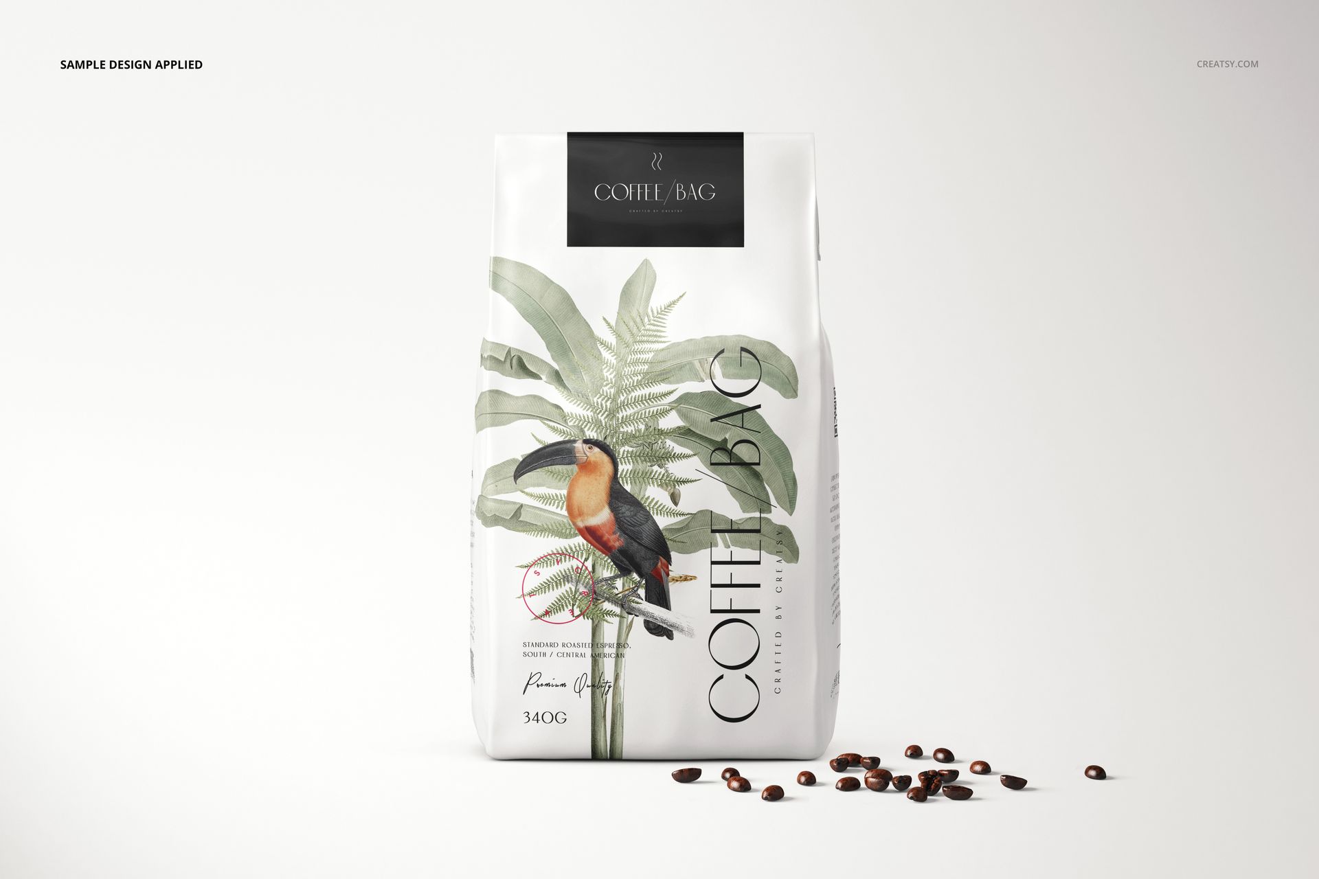 Paper coffee bag mockup featuring a toucan and palm design, shown upright with coffee beans on a plain background.