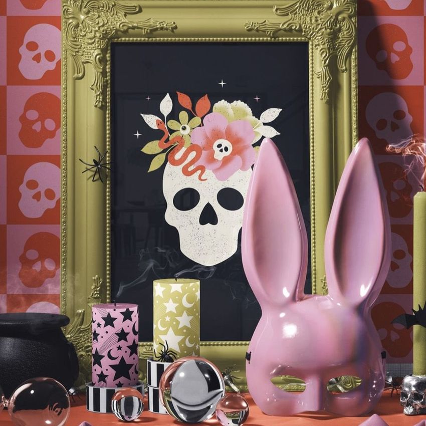 Halloween picture frame mockup featuring ornate gold frame with skull art print, surrounded by candles and festive props.