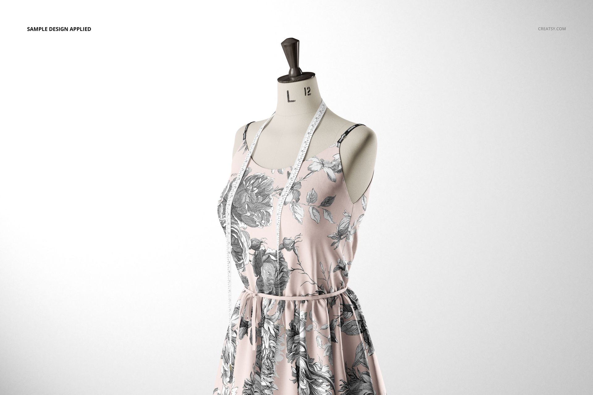 Fabric dress mockup displayed on a mannequin with a light pink and gray floral design, measuring tape over the shoulders.