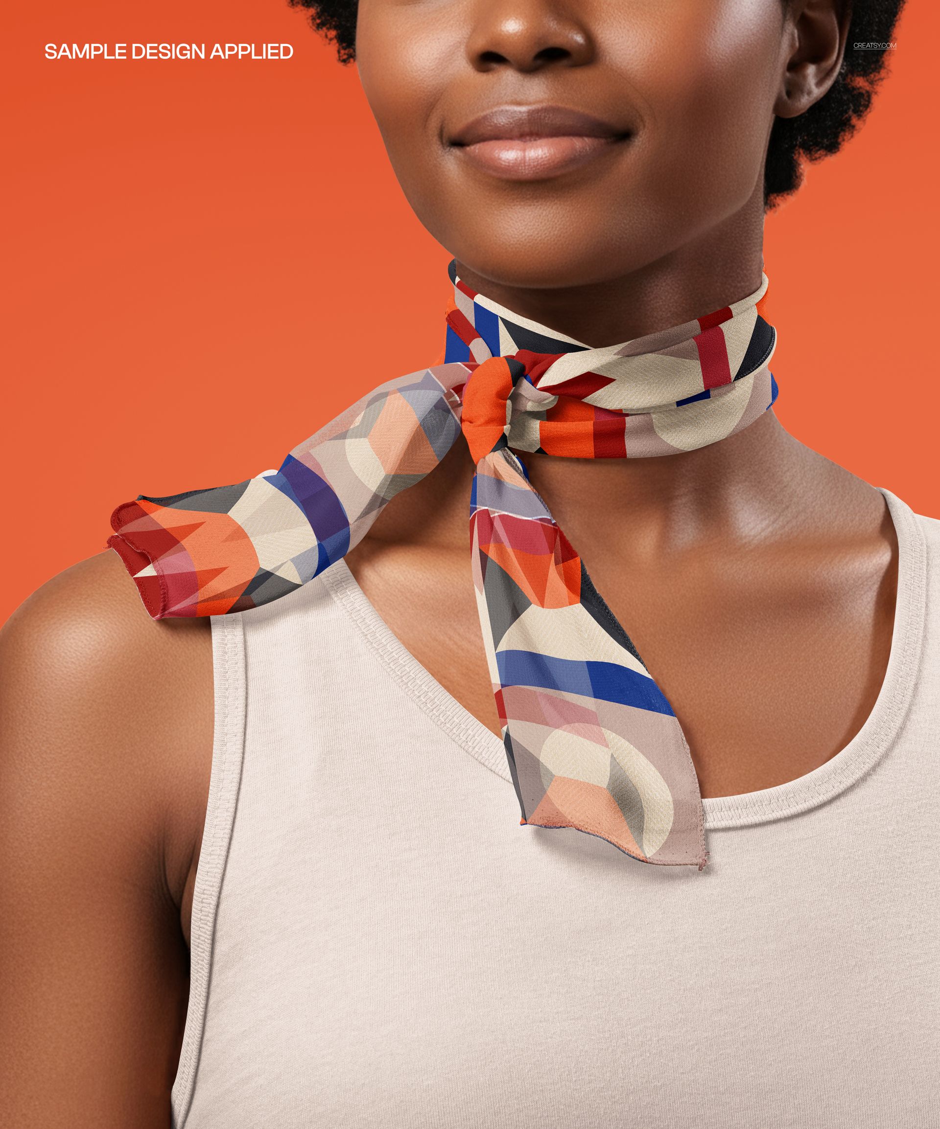 Chiffon silk scarf mockup featuring geometric patterns in orange, blue, and beige, tied around the neck.