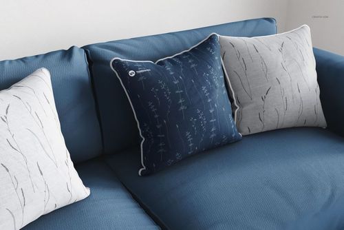 Square cushion PSD mockup set displayed on a blue couch, showing varied leaf patterns and contrasting piping details.