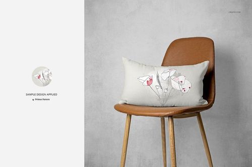 PSD mockup showing a rectangular pillow with simple flower illustrations, displayed on a modern brown chair.
