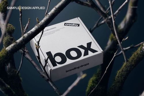 Rectangular mailing box mockup with a white surface and black text, positioned among mossy tree branches.