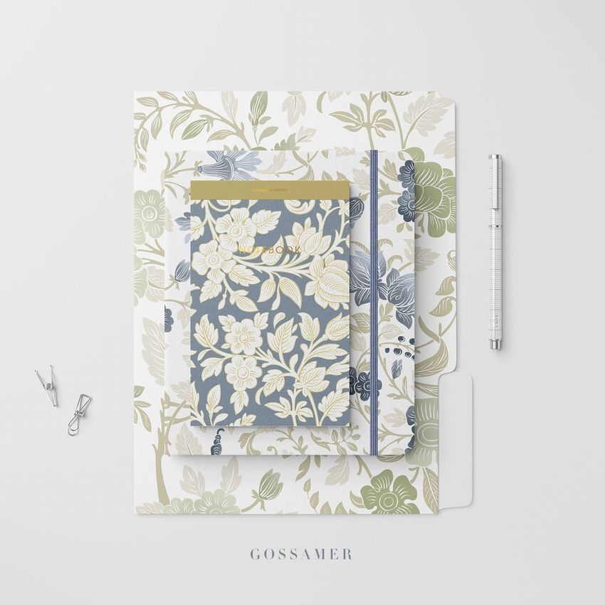 Stationery set mockup featuring a floral notebook, folder, and card arranged on a white surface with a pen and clips.
