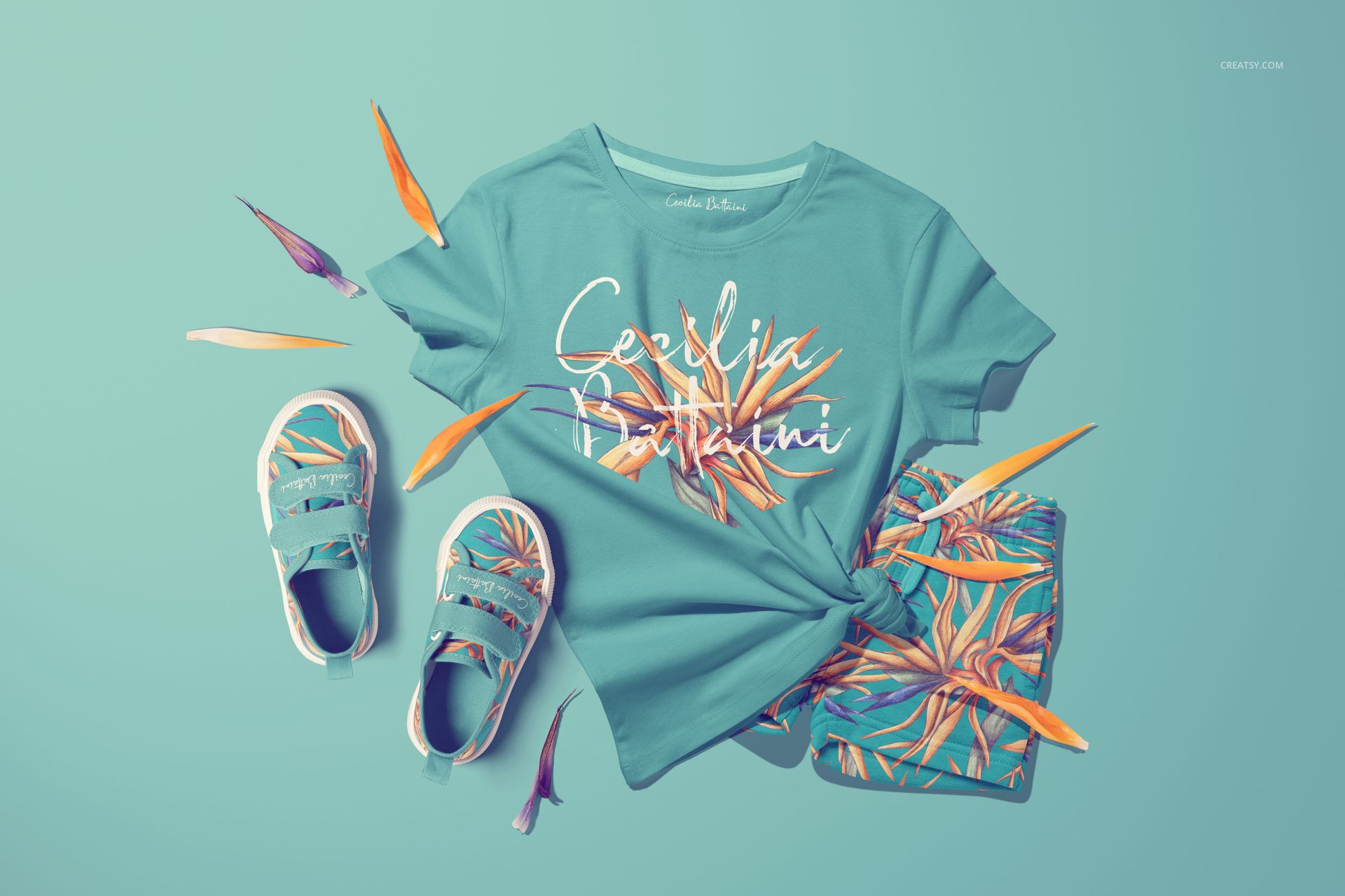 PSD mockup showing kids summer outfit with floral elements, including t-shirt, shorts, and shoes on a blue surface.