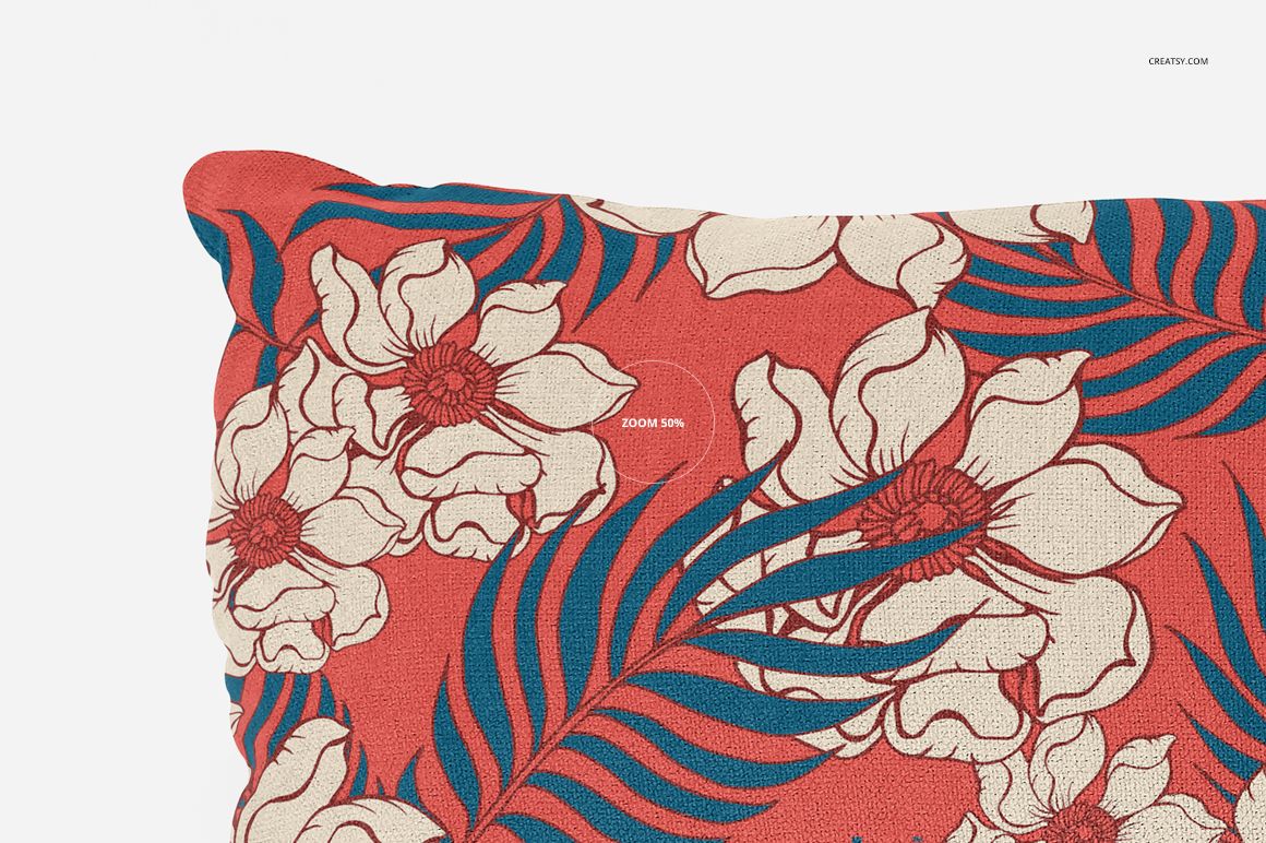 Close-up of a long pillow mockup with a bold floral pattern in white and blue on a textured red surface.