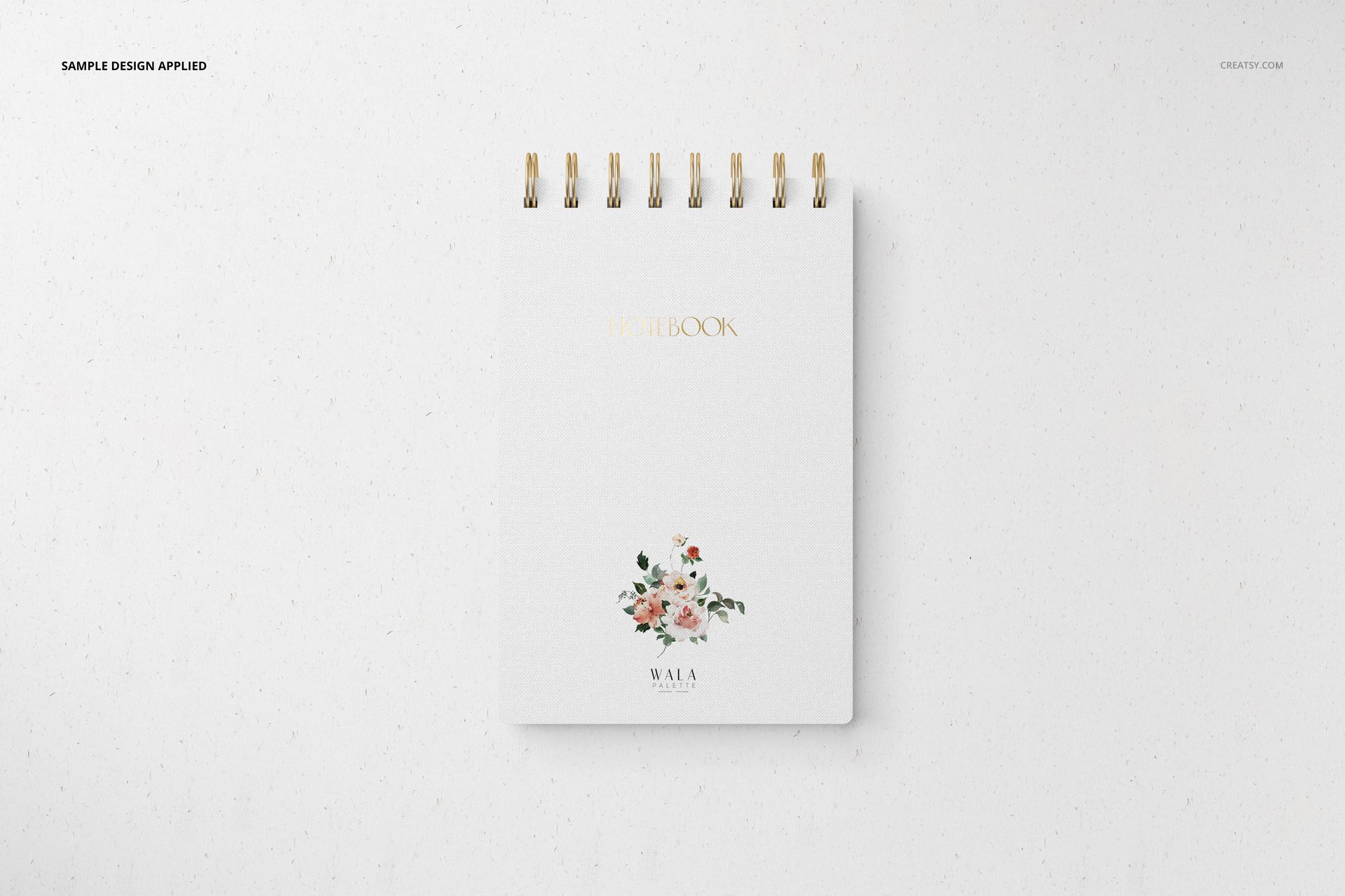 Front view of a spiral-bound stationery notebook mockup with a white cover, gold text, and floral illustration.
