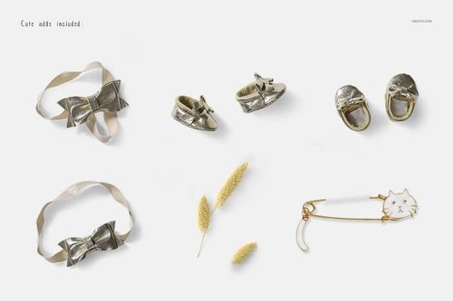 Baby dress mockup accessories including gold shoes, ribbon bows, dried flowers, and a cat-shaped safety pin on a white background.