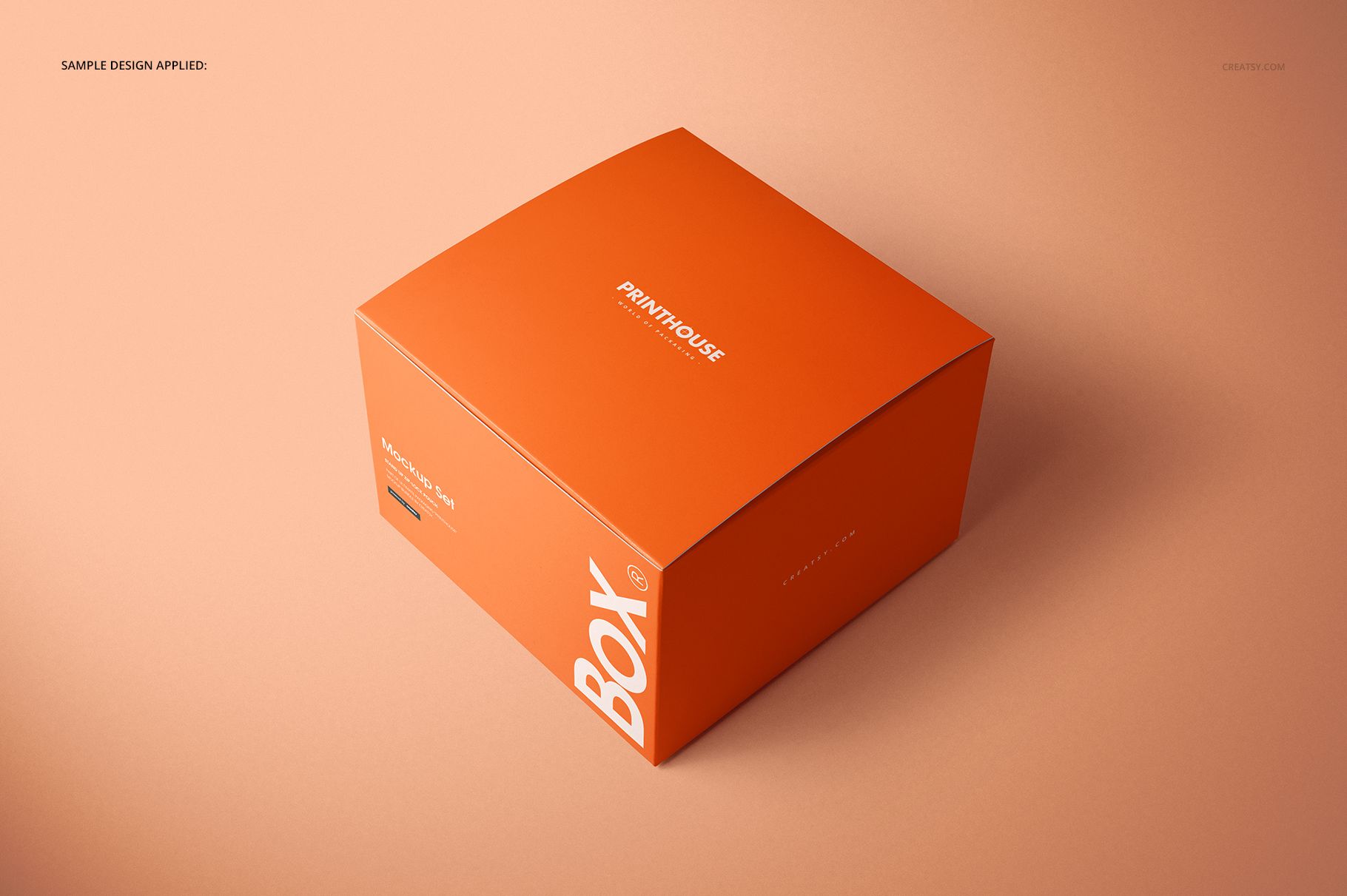 Orange chipboard gift box mockup with gloss finish, featuring white lettering, displayed in a studio setting.