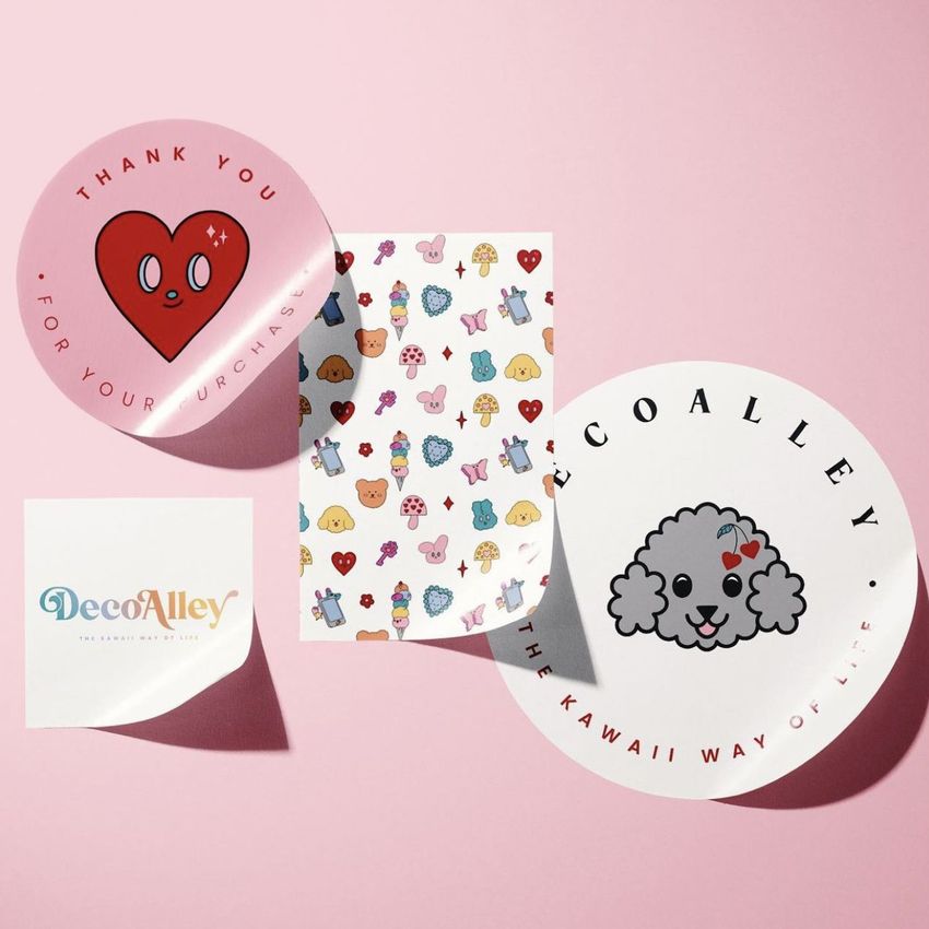 Sticker mockup scene featuring round and square stickers with cute cartoon designs and playful pastel colors on a pink background.