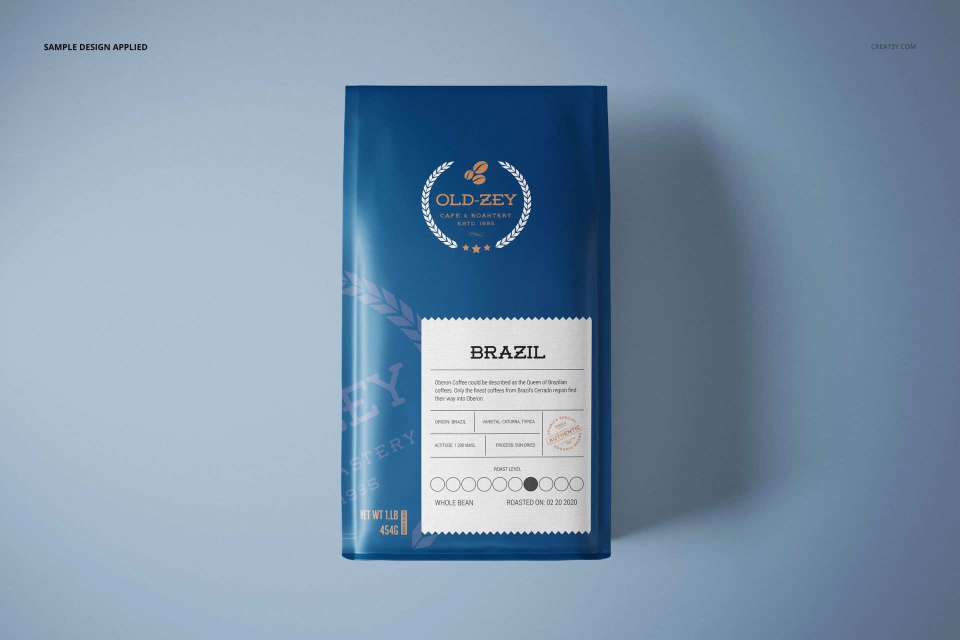 Blue paper coffee bag mockup featuring a white label and circular logo, displayed on a smooth light blue surface.