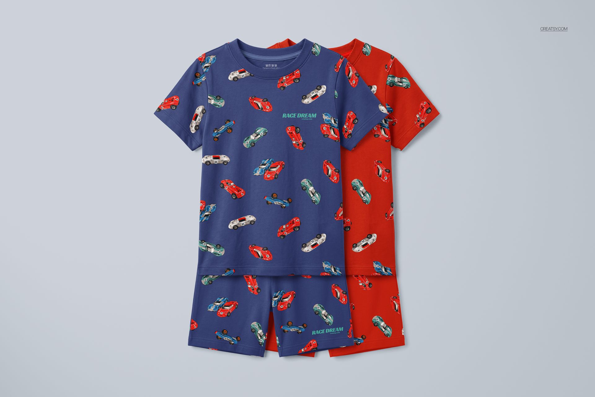 PSD mockup showing two short-sleeve kids pyjama sets with colorful car prints, one blue and one red, side by side.