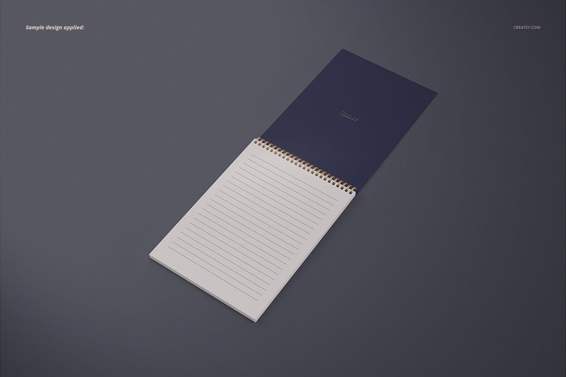 Top view of an open A4 spiral notebook mockup showing a navy cover and lined paper on a neutral background.
