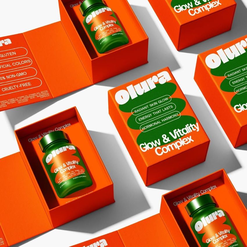 Cosmetics box packaging mockup featuring several orange boxes with green supplement bottles inside, arranged on a white surface.