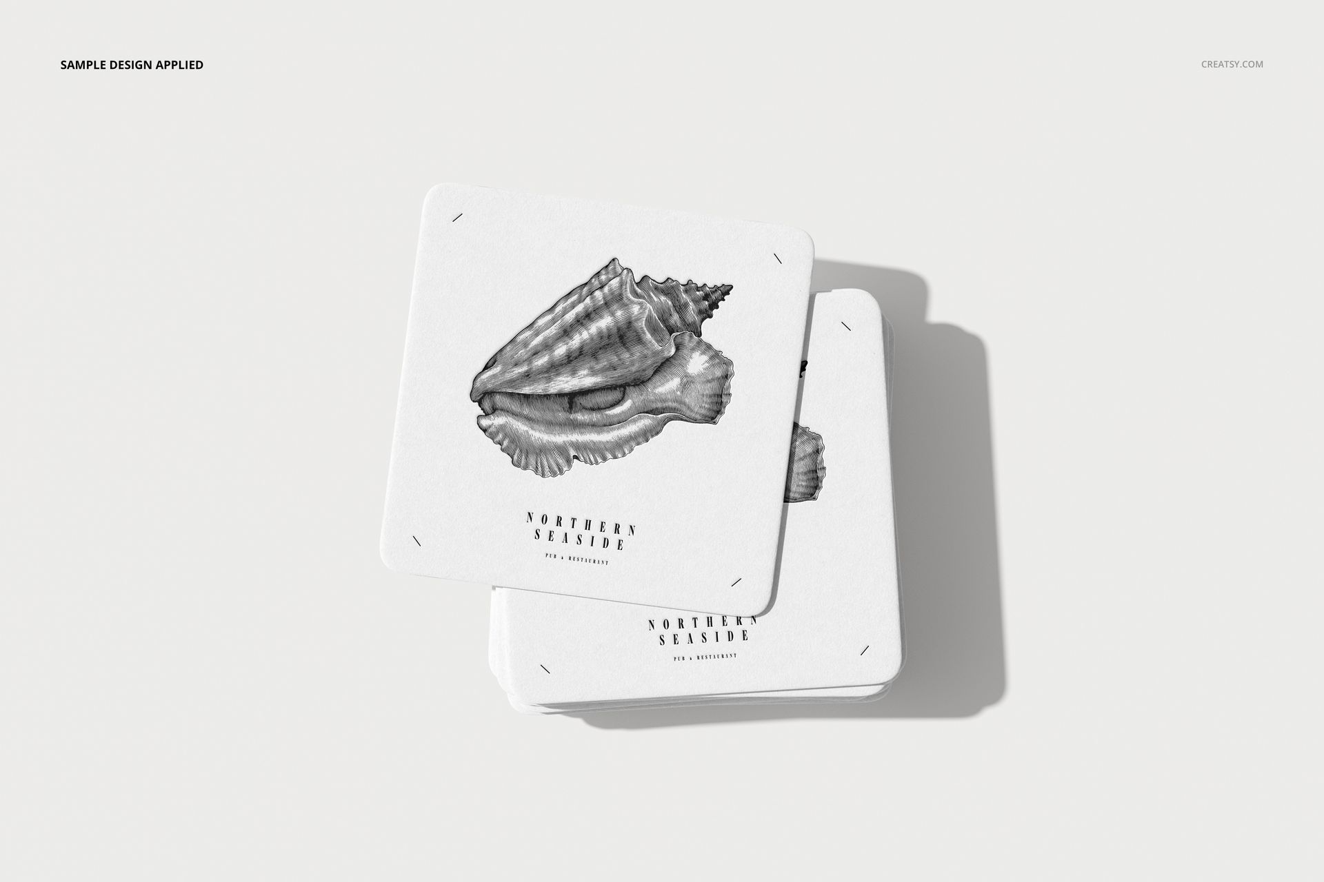 Square coasters mockup featuring a black and white seashell design and text, displayed on a plain surface.