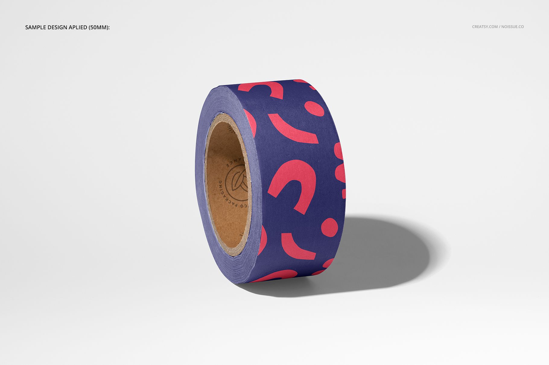Mockup of a packaging tape roll with playful pink graphics on a dark purple surface, isolated against a white backdrop.