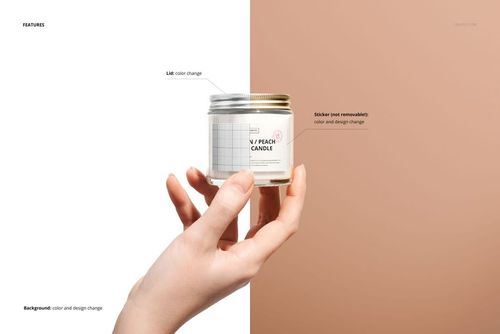 Close-up of a person's hand presenting a glass candle jar with a silver lid and customizable white label, mockup scene.
