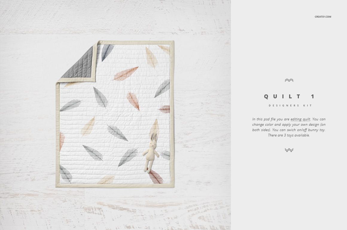 Crib bedding mockup showing a quilt with multicolored feather design and a small plush bunny on a light background.