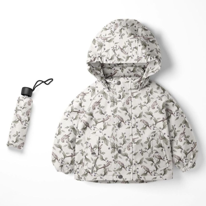 Kids rainwear mockup featuring a hooded jacket and matching umbrella with a bird and branch pattern on a white background.