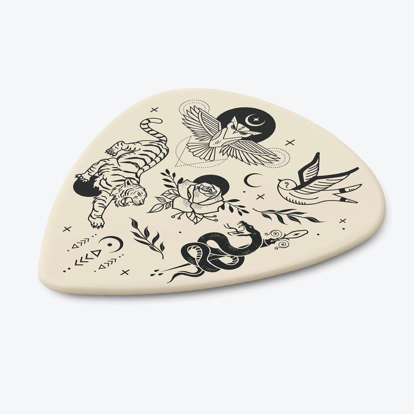 Guitar pick mockup featuring black tattoo-style illustrations of a tiger, owl, snake, rose, and bird on a cream background.