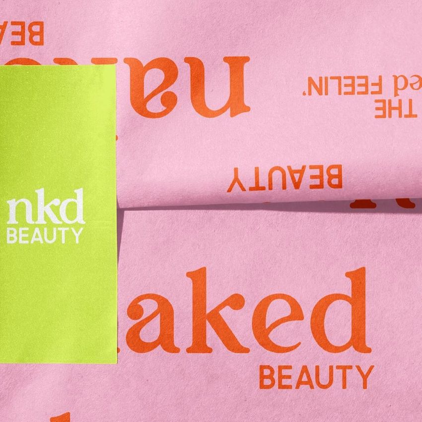 Wrapping paper mockup featuring pink paper with bold orange text and a green sticker labeled with white text on the left side.