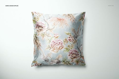 Front view of a mockup featuring a square cushion cover with pastel floral and bird patterns on a soft blue base.