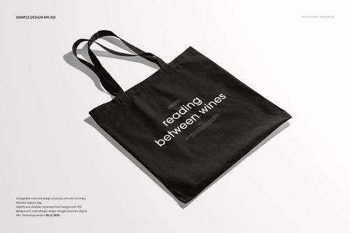 Black tote bag mockup displayed on a light surface, featuring white text in the center and long handles.