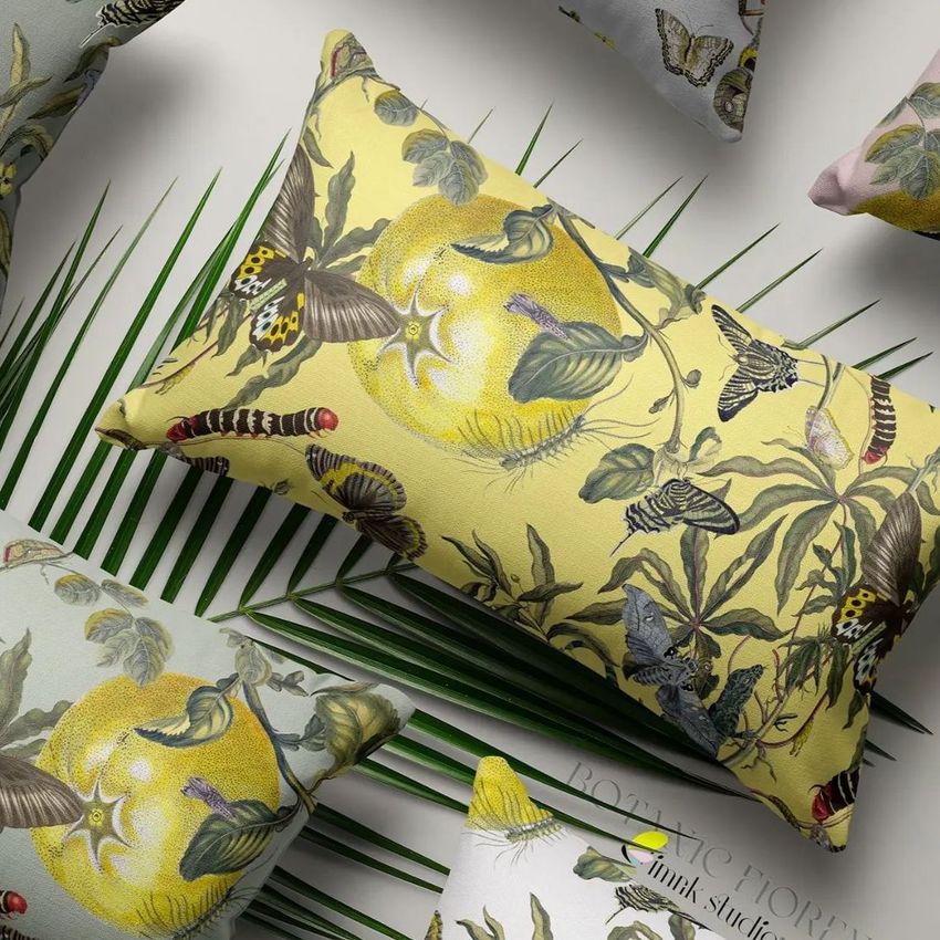 Rectangular pillow mockup featuring a botanical pattern with butterflies and fruit on a yellow background, arranged on palm leaves.