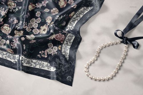 Silk scarf mockup featuring intricate floral designs and decorative border, shown from above on a pale background.