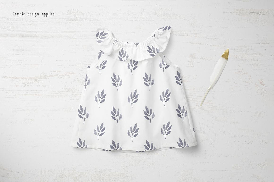 Baby summer set mockup showing a sleeveless white top with gray leaf prints, arranged on a pale wood background.