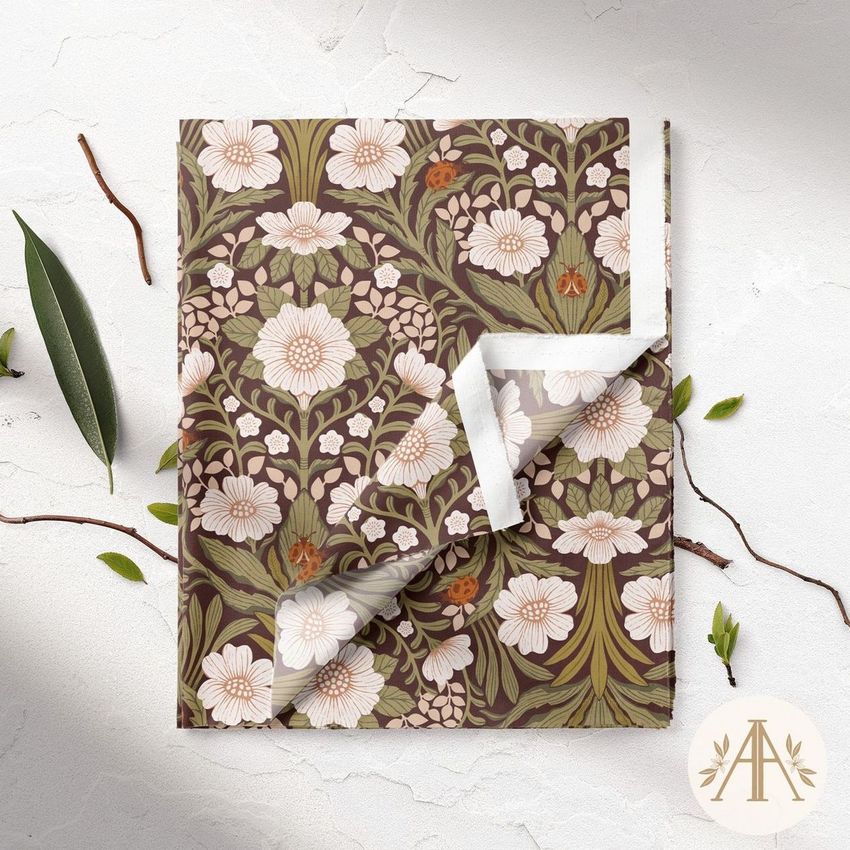 Folded fabric mockup featuring a floral pattern with white and pink flowers and green leaves on a dark background, seen from above.
