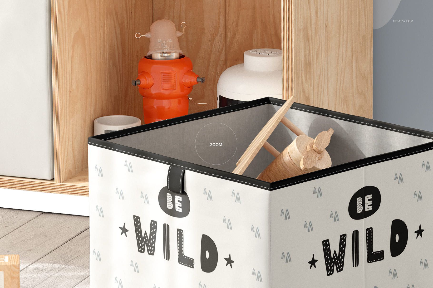 Square folding storage box mockup featuring whimsical patterns and text, placed on a light wood floor near shelves.